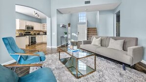 A spacious living room with a sofa, armchairs, and a glass coffee table. - New Centrally Located North Richland Hills Home (North Richland Hills)