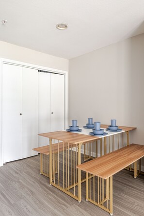 Ein Zimmer mit einem Holztisch, Bänken und einer weißen Tür.