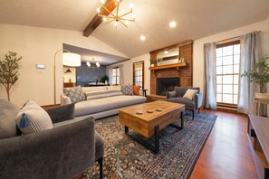 A living room with a sofa, armchairs, a coffee table, a fireplace, and a patterned rug. - Wonderful 4-bedroom minutes from Trilith, QTS and U.S. Soccer Training Facility (Fayetteville)