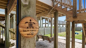 Eine Holzhütte mit einem Schild, das 'SALTY TURTLE BEER' zeigt.
