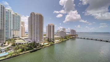 A high-rise hotel with multiple floors, a swimming pool, and a waterfront view.