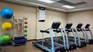 A fitness area with treadmills, exercise balls, and a wall-mounted sign.