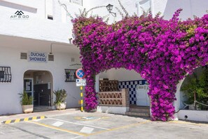 A building with a sign for 'DUCHAS SHOWERS' and a no parking sign. - Luxe Marina Premium Port views I (Almuñécar)