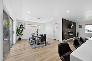 A modern dining area with a table, chairs, and a potted plant. - Beautiful 3-bedroom house in peaceful Scottsdale perfect for relaxing stays (Scottsdale)