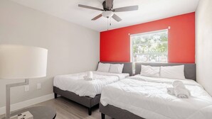 A hotel room with two beds, a ceiling fan, a window with a view, and a lamp. - Cozy 1BR with 2 Beds @5 min walk to NRG & near TMC (Houston)