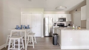 A modern kitchen with white cabinetry, stainless steel appliances, and a granite countertop. - Cozy 1BR with 2 Beds @5 min walk to NRG & near TMC (Houston)