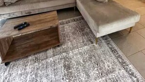 A living room with a grey sectional sofa, a wooden coffee table, and a large abstract painting on the wall. - Pleasant King 1Bed 1Bath Near Med Center with Pool (Houston)