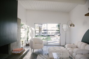 A modern living room with a sofa, armchair, and a glass coffee table. - Electric Lady House Palm Springs Alexander (Palm Springs)