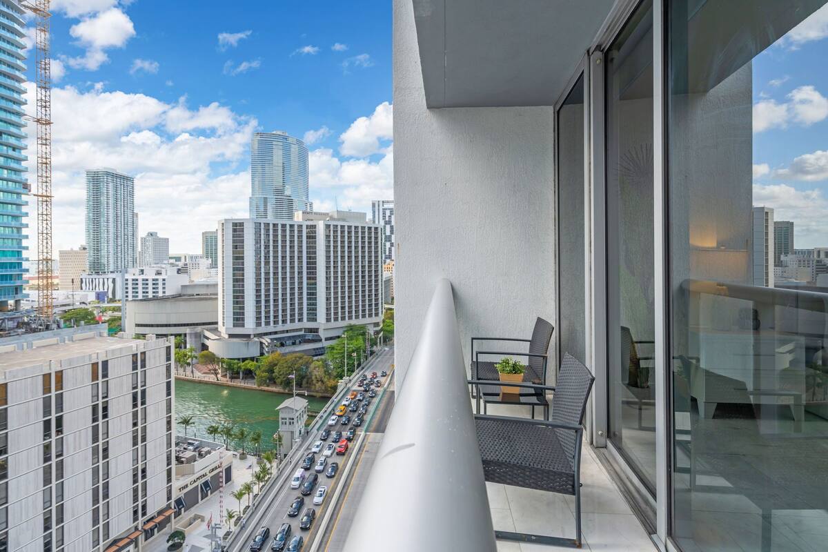 Un edificio alto con vistas a una calle concurrida y otros edificios.