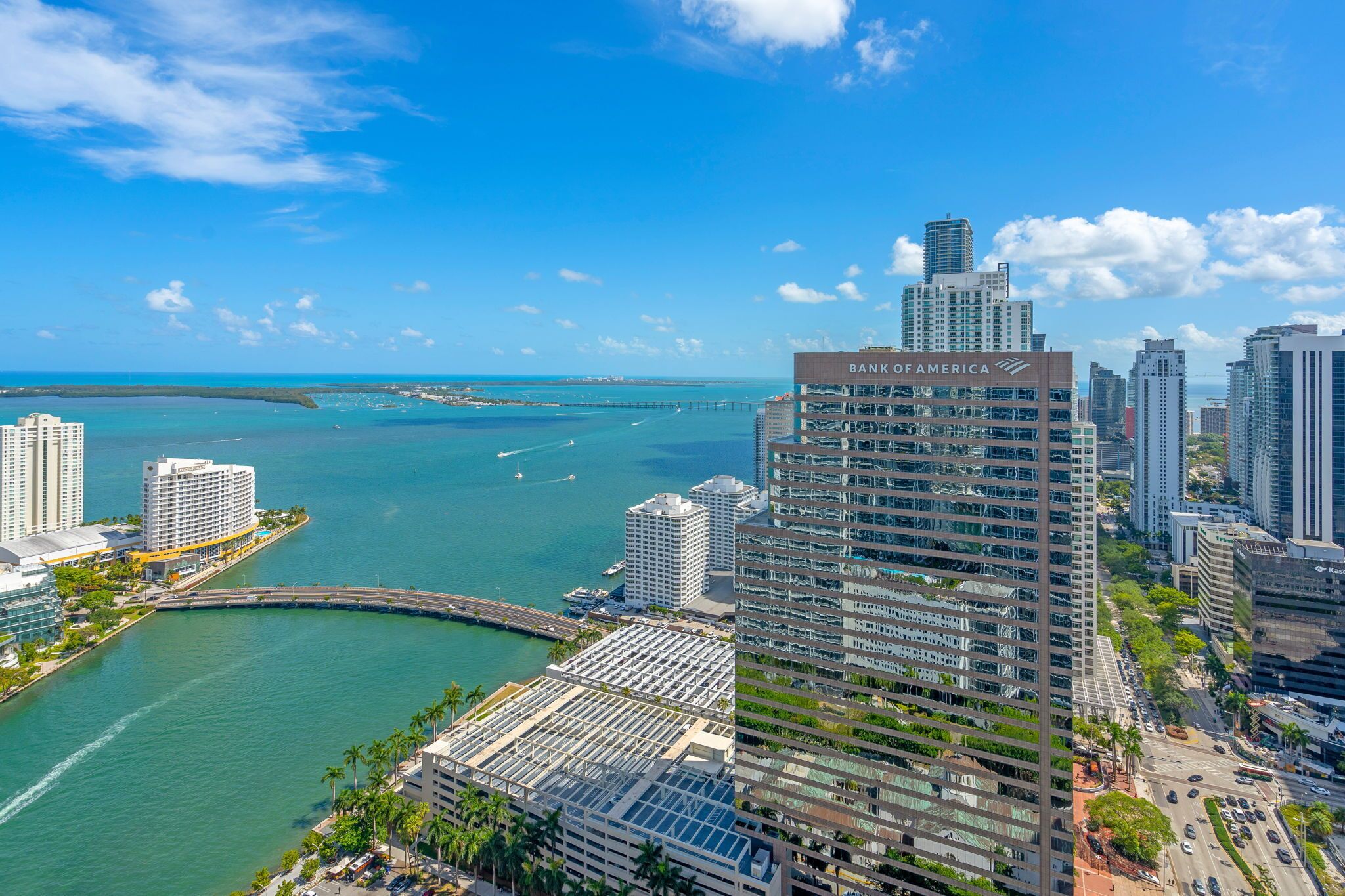 A high-rise hotel with a view of the ocean and a bridge.