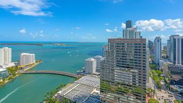 A high-rise hotel with a view of the ocean and a bridge.