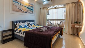 Een slaapkamer met een bed, een plafondventilator, een airconditioningapparaat, een raam met gordijnen en een wandplank.