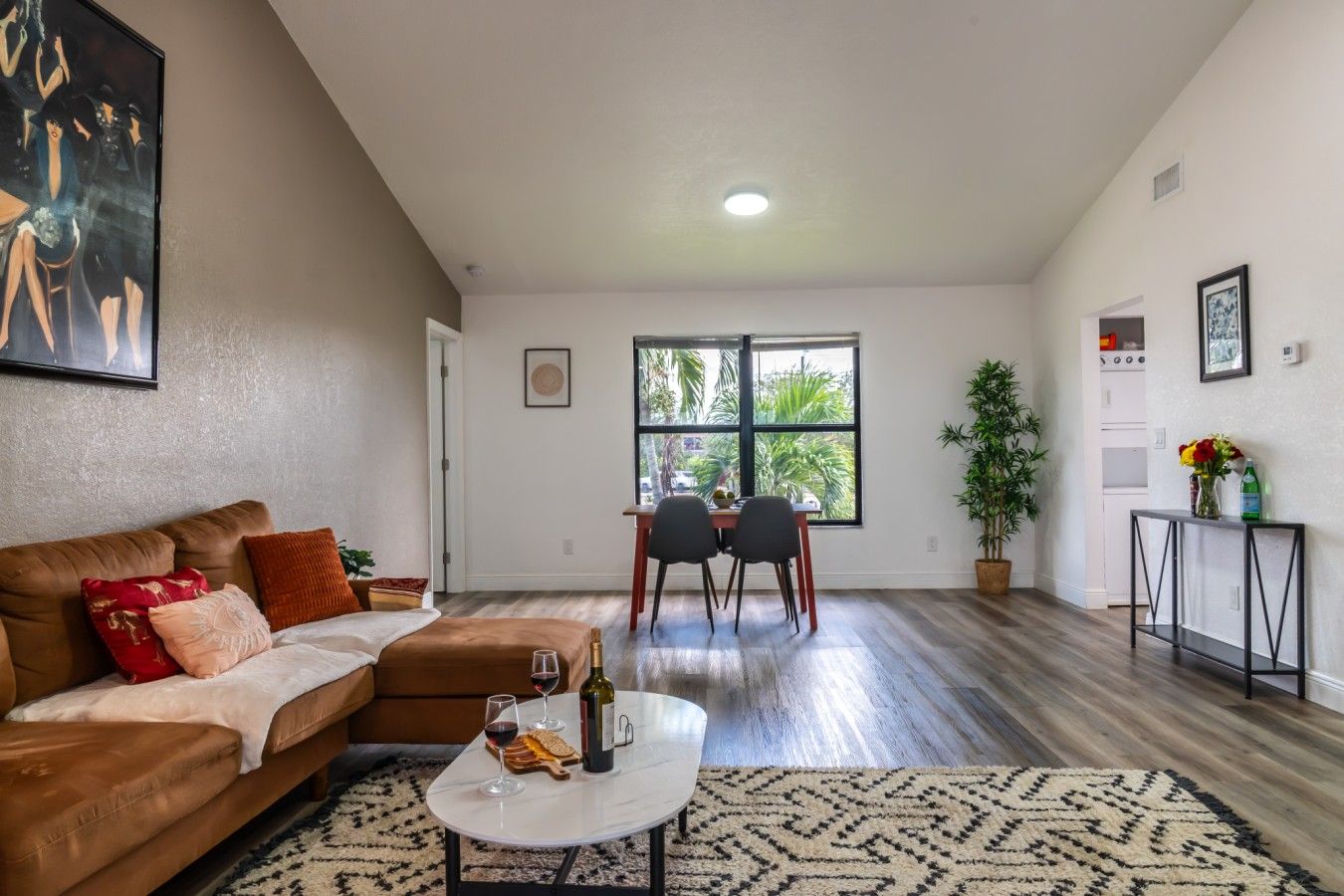 A living room with a sofa, coffee table, and dining area with chairs.