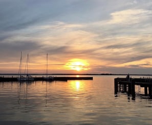 A sunset over a calm body of water with boats docked at a pier. - Baltic Sea time-out - near Darß - relaxation in the midst of nature (Pruchten)