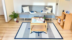 A living room with a sofa, coffee table, and a lamp. - Baltic Sea time-out - near Darß - relaxation in the midst of nature (Pruchten)