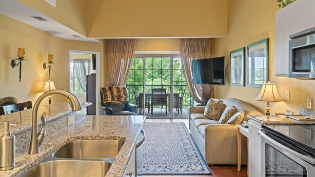 A kitchen with granite countertops, stainless steel sinks, and a built-in oven.