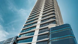 Ein hohes, modernes Gebäude mit einer geschwungenen Fassade und großen Fenstern.