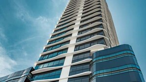 A tall, modern building with a curved facade and large windows.