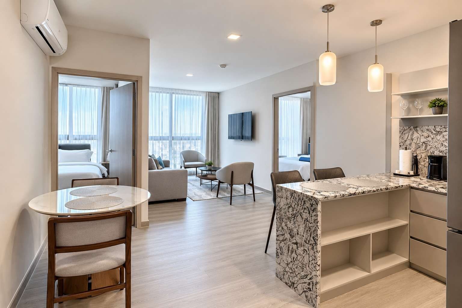 A modern hotel room with a dining area, a kitchen, and a living space.