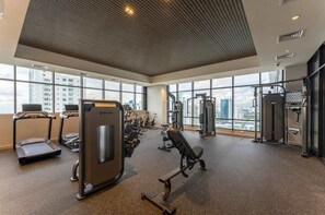 Een sportschool met loopbanden, krachttoestellen en trainingsapparatuur.