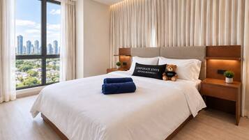 Habitación de hotel con una cama grande y vistas de la ciudad, mostrando un paisaje urbano a través de la ventana.