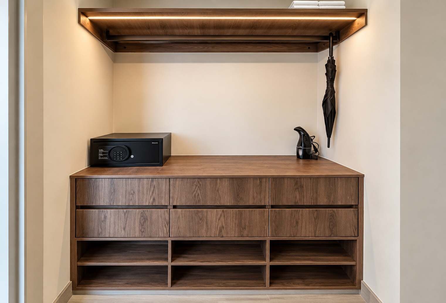 A wooden console with a built-in speaker and a kettle, a wall-mounted umbrella, and a shelf with a kettle.