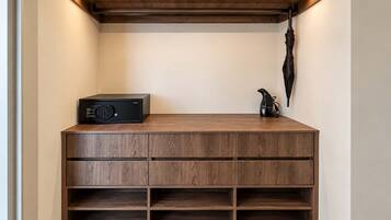 A wooden console with a built-in speaker and a kettle, a wall-mounted umbrella, and a shelf with a kettle.