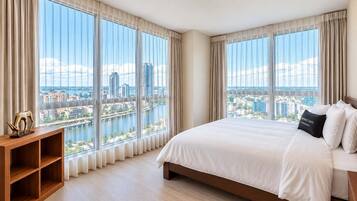 Een hotelkamer met een groot bed, een houten nachtkastje en een uitzicht op een stadslandschap door middel van vloerhoog raam.