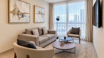 Een moderne woonkamer met een bank, fauteuil, salontafel en kunstwerken aan de wanden.