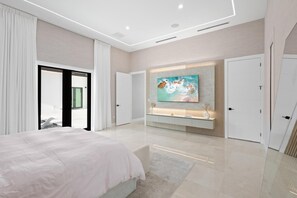 A modern bedroom with a large bed, a TV mounted on the wall, and a sliding door leading to a balcony. - Luxury Meets Miami (Miami)