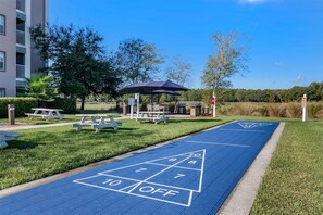 A blue shuffleboard court with picnic tables and a gazebo in a park setting. - Hilton Vacation Club St. Augustine (St. Augustine)