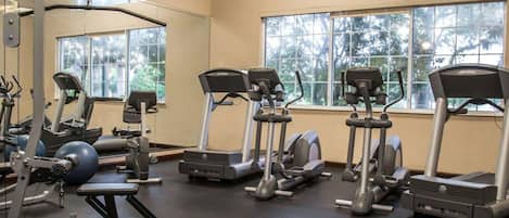 A gym with treadmills, elliptical machines, and weight equipment.