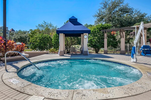 Ein Whirlpool mit Gazebo, ein Schwimmbad und eine überdachte Terrasse.