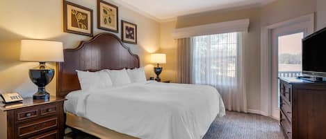 Une chambre d’hôtel avec un grand lit, deux tables de chevet avec des lampes, une télévision et une fenêtre avec des rideaux.