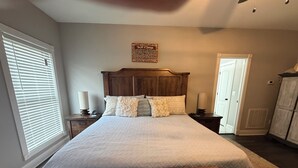 Une chambre à coucher comprenant un lit, une table de chevet, une horloge murale, un objet décoratif et une armoire.