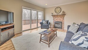Una sala de estar con chimenea, televisor y sofá.