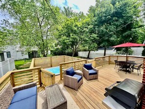 A wooden deck with outdoor furniture, a hot tub, and a barbecue grill. - Charming Home with Hot tub & walk to town! (Three Oaks)