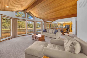 A spacious living room with large windows, a wooden ceiling, and a cozy seating area. - AC, View of Golf Course, Ping Pong, by North Store (Sunriver)