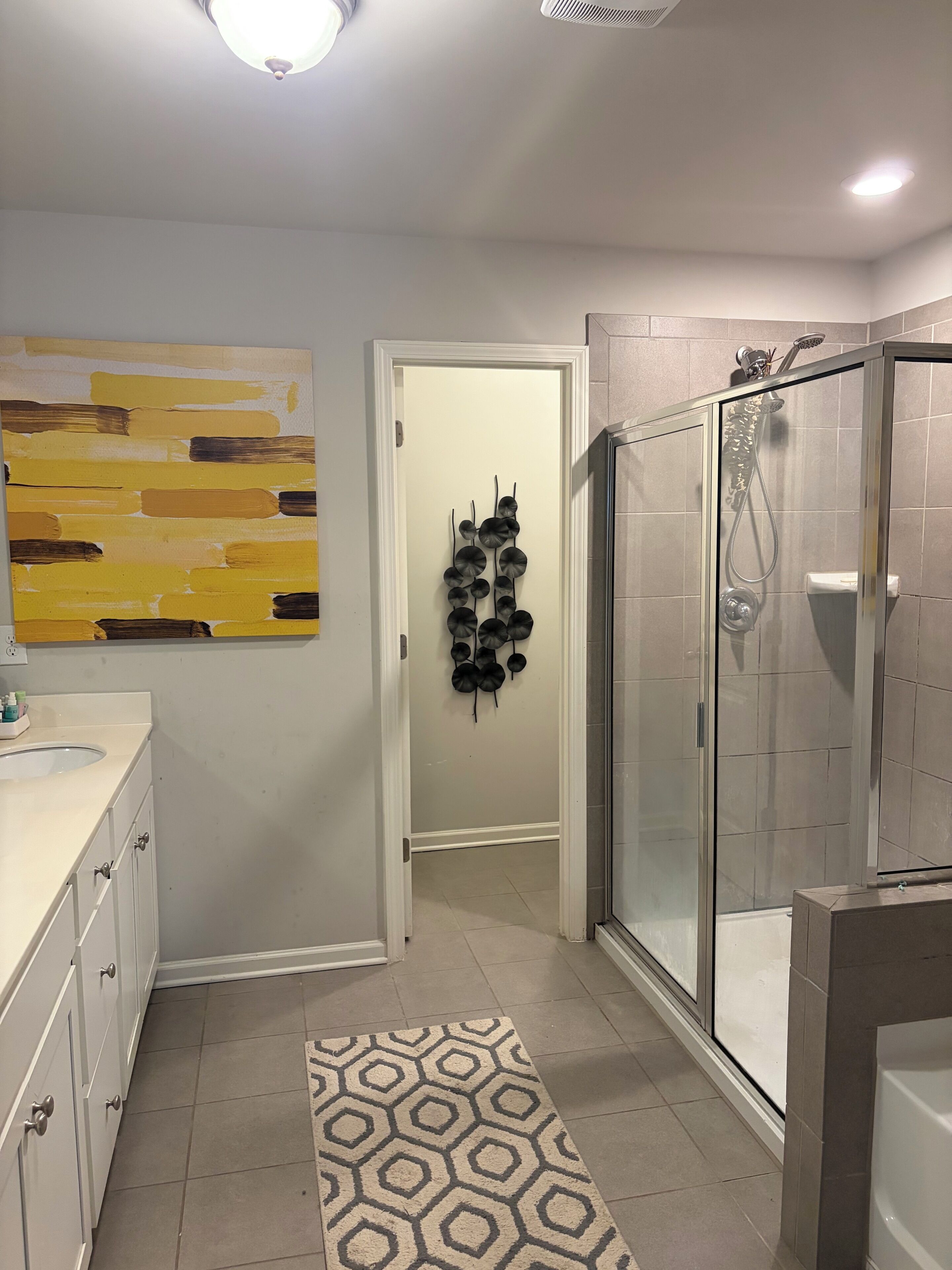 A modern bathroom with a shower, a sink, and a mirror.