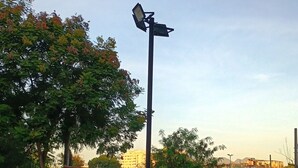 A fenced park area with a street lamp, playground equipment, and a bicycle rack. - O melhor de Madureira  (Rio de Janeiro)