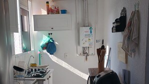 A compact kitchen with a gas stove, sink, and a small refrigerator. - O melhor de Madureira  (Rio de Janeiro)