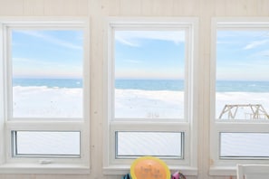 Three windows with a view of the beach and ocean.
