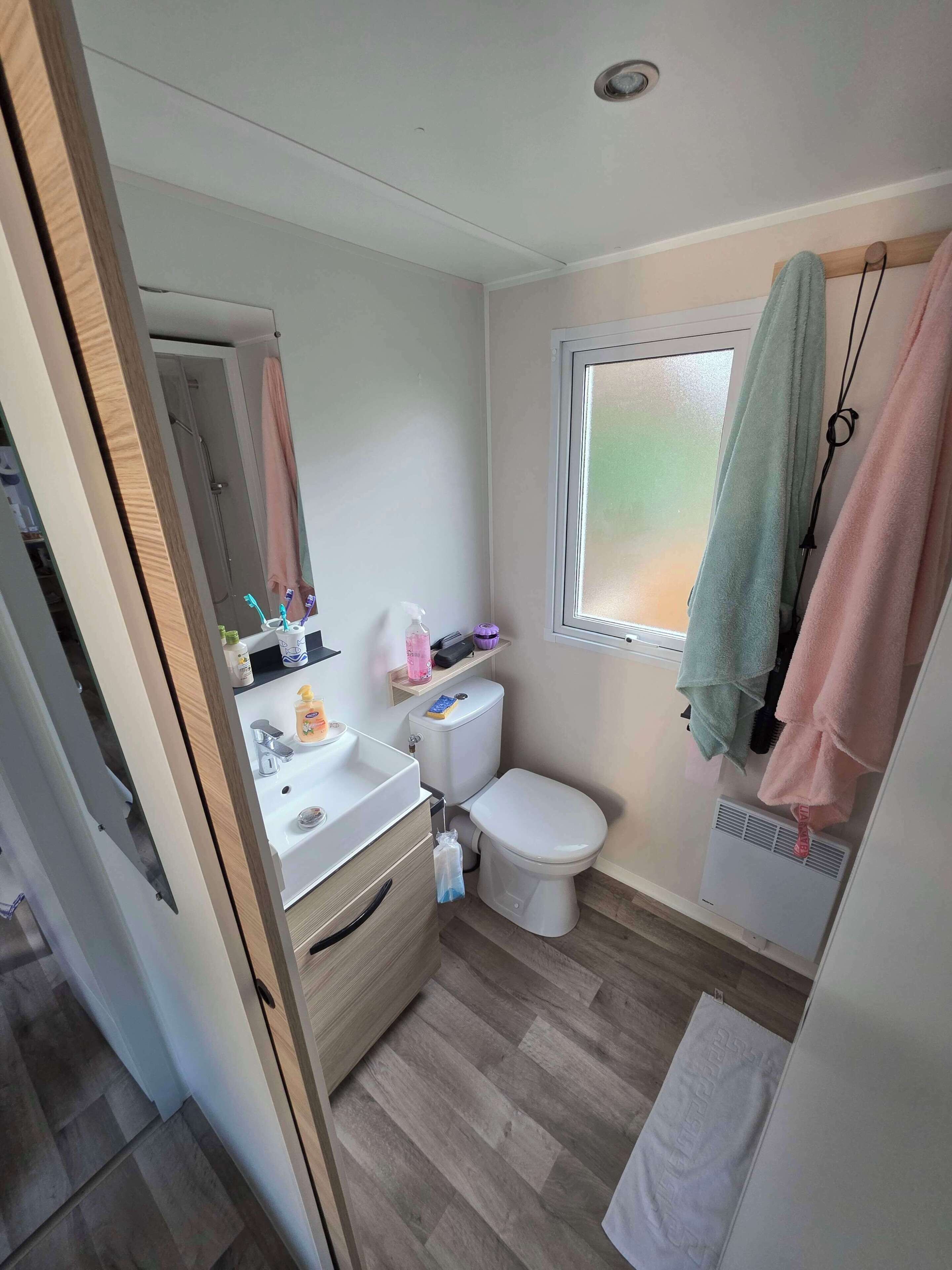 Un baño pequeño con inodoro, lavabo y ventana.
