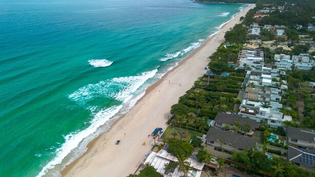 An aerial view of a beach with a row of houses along the shoreline. - Casa em Maresias Para 8 Pessoas a 350m da Praia (São Sebastião)