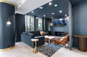 Ein modernes Wohnzimmer mit Sofa, Couchtisch und Fernseher.