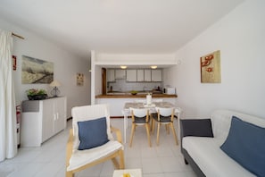 A compact living space with a dining area, kitchenette, and a sofa. - Apto 115 (Costa Teguise)