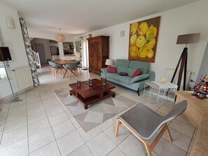 A living room with a sofa, coffee table, and a painting.