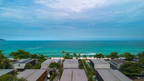 A coastal view with a beach, ocean, and modern buildings with flat roofs. - Casa com rea Gourmet a 350m da Praia de Maresias (São Sebastião)