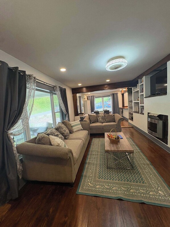 A spacious living room with a sectional sofa, a coffee table, and a fireplace.