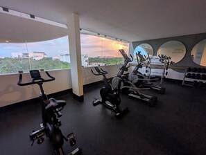 Ein Fitnessraum mit Ergometer, Crosstrainern und Kurzhanteln.